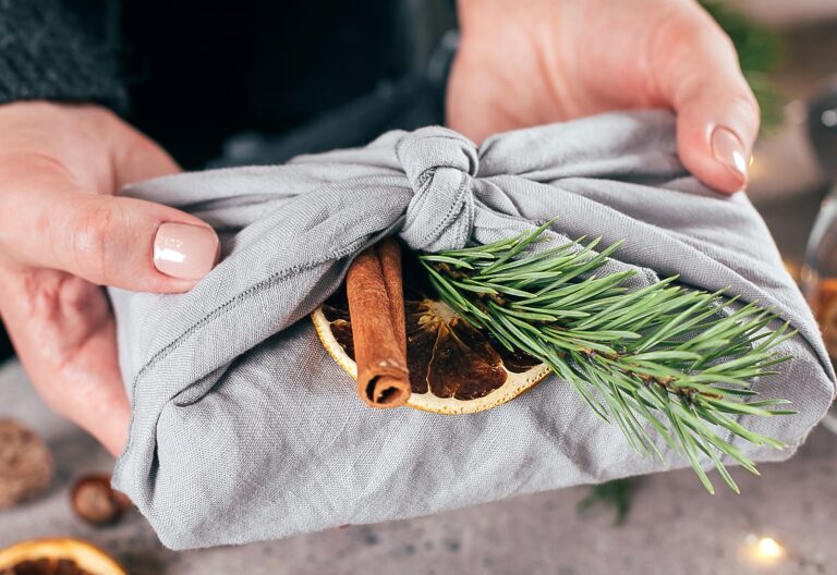 Eco-Friendly Gift Wrapping feature - linen-wrapped gift with greenery, cinnamon stick, and dried fruit