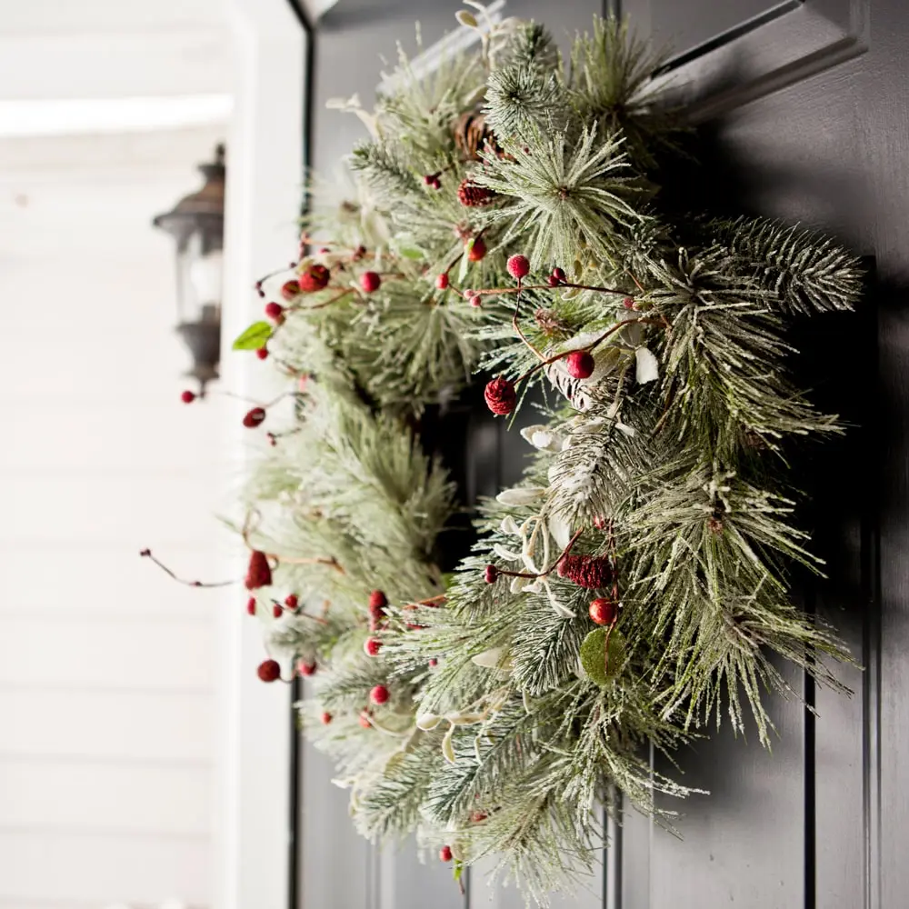 using Christmas greenery to create a door wreath can help build holiday spirit with visitors