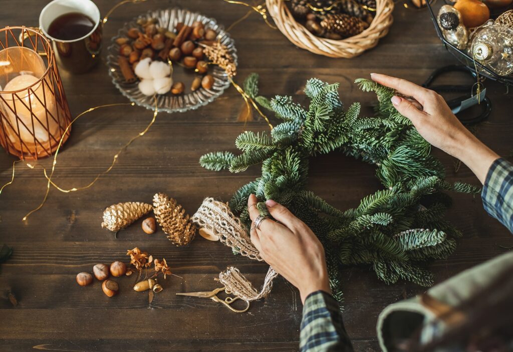 using christmas greenery feature - woman making a small Christmas wreath from greenery clippings